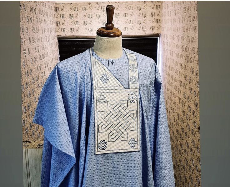 Light blue agbada with a cream embroidered chest panel on a mannequin