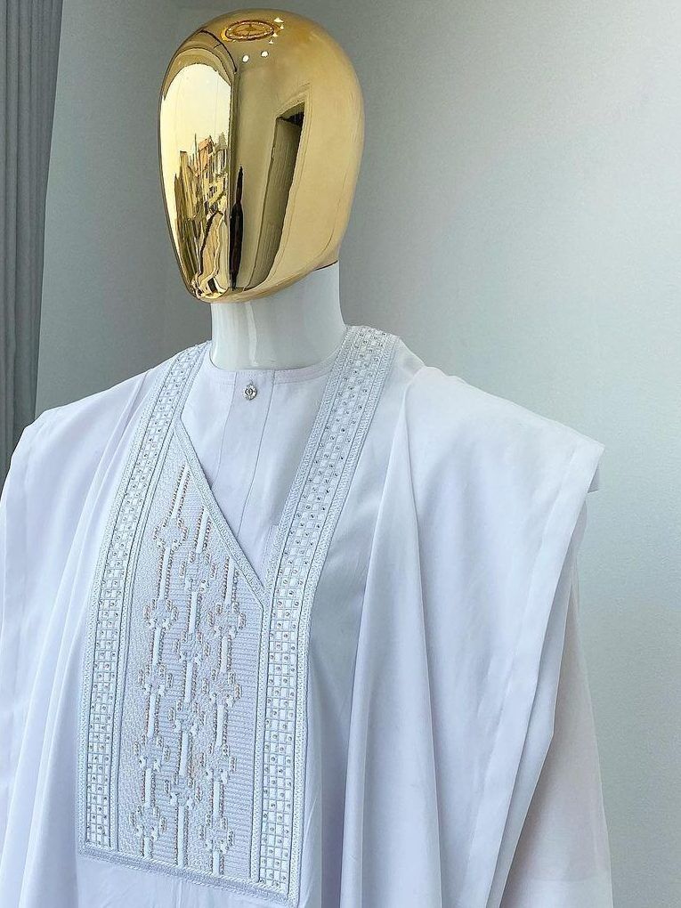 Ivory white agbada set with embroidered chest panel on a gold-headed mannequin