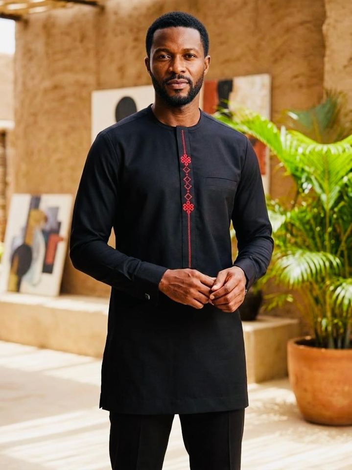 Man in a black two-piece set with red embroidery down the chest